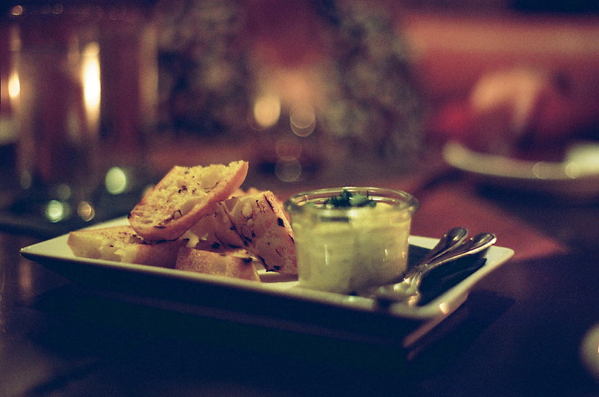 Gourmet appetizer with grilled bread and dip in dim restaurant