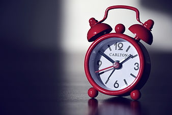 Red Carlton Alarm Clock on Dark Surface