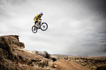 Mountain Biker Jumping in Desert Canyon