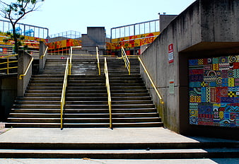 Concrete Staircase with Yellow Rails and Colorful Mosaic Art