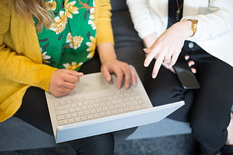 Two women collaborating on a laptop in a casual office setting