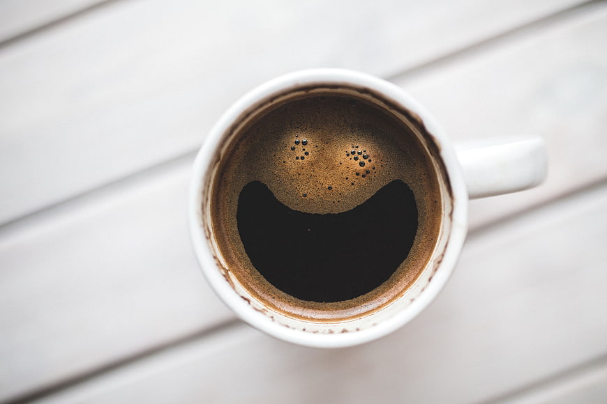 Top view of coffee cup with smiley face foam art
