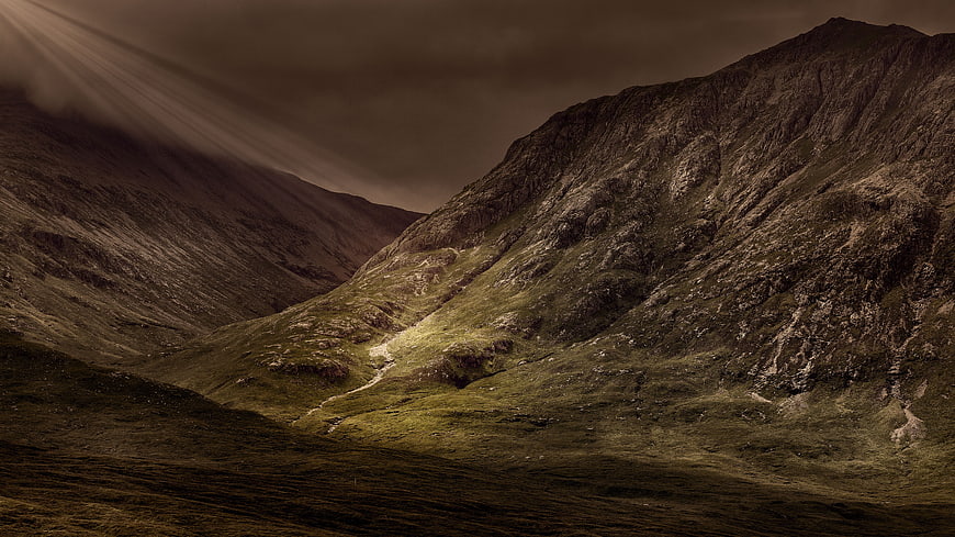 Dramatic Mountain Landscape with Sunbeams and Green Valley