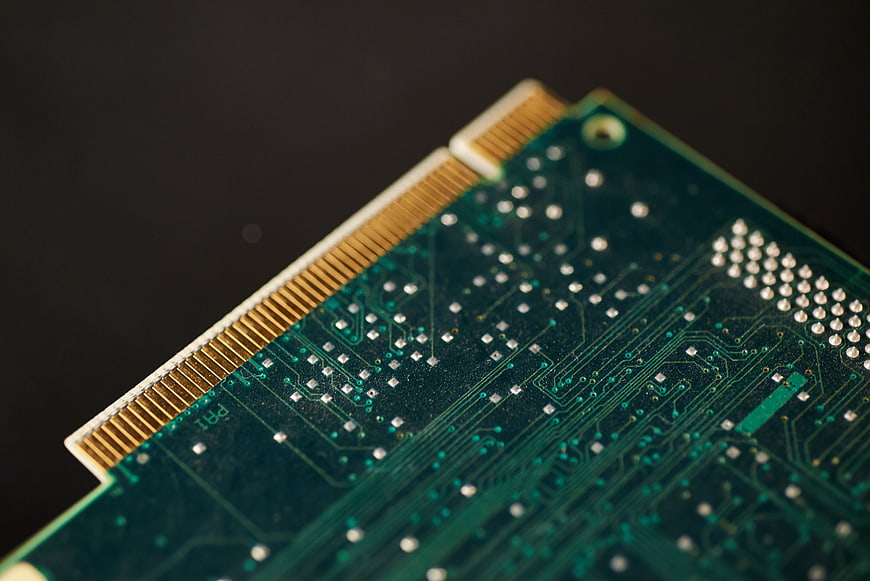 Close-up of green circuit board with gold connector pins