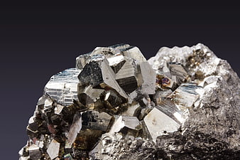Close-up of shiny metallic pyrite crystals on dark background