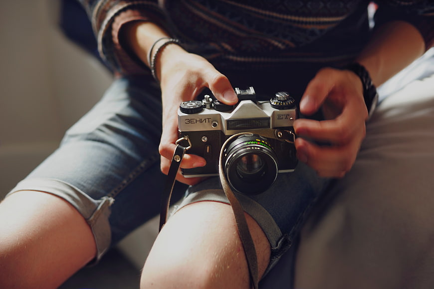 Person holding vintage Zenit film camera on lap