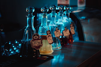 Row of glass decanters with colorful liquids on a bar counter