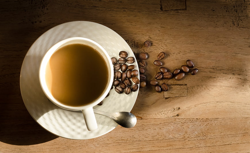 Top View of Coffee Cup with Beans on Wooden Table