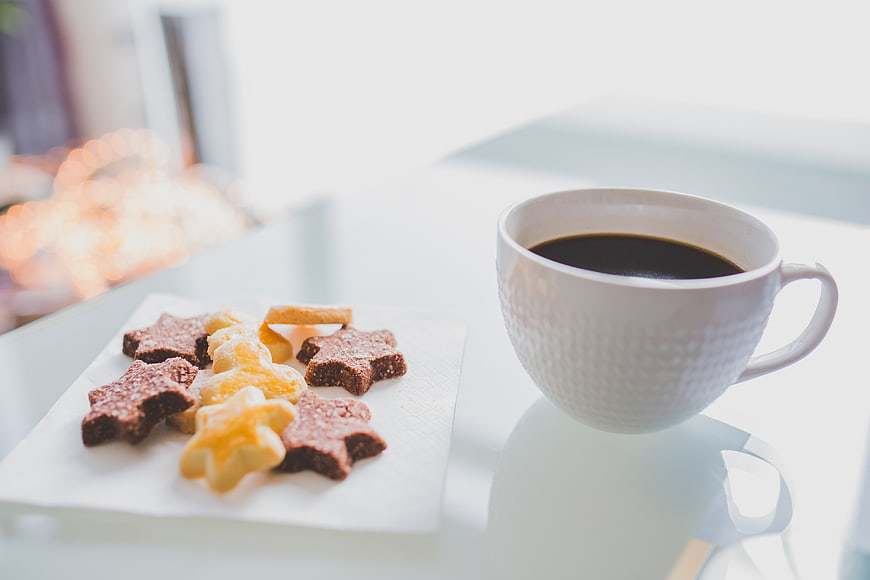 White coffee cup and star-shaped cookies on a table