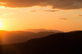 Golden Sunset Over Silhouetted Mountain Ranges