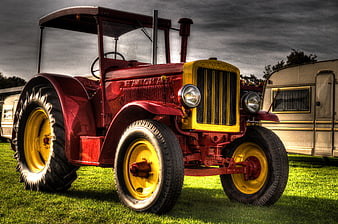 Vintage red Farmall tractor with yellow accents on grass