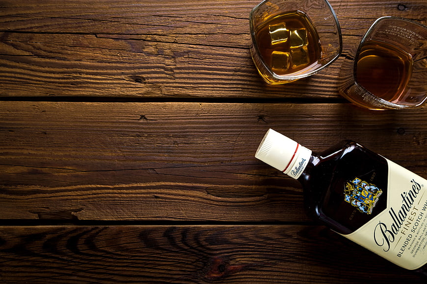 Ballantine's Scotch Whisky Bottle and Glasses on Wood