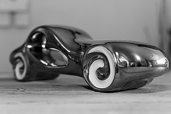 Close-up of a shiny metallic toy car on wood
