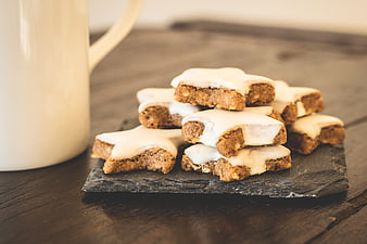 Star-shaped gingerbread cookies with white icing on slate