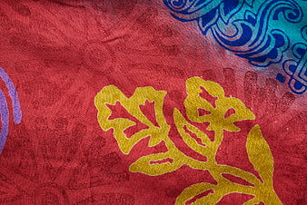 Close-up of vibrant red textile with yellow and blue floral patterns