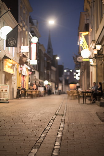 Cobblestone Street at Night with Blurred City Lights