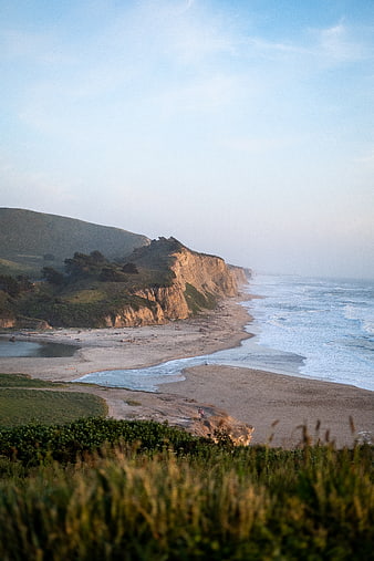 Scenic coastal landscape with cliffs, sandy beach, and ocean waves