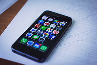 Black smartphone on notebook with handwritten notes