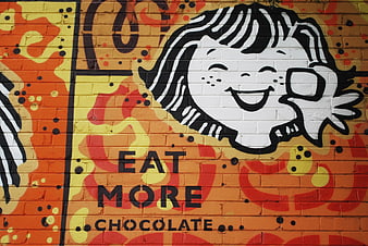 Colorful street art mural with cartoon face and chocolate message