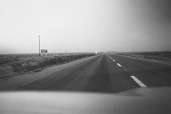 Vintage black and white photo of a lonely highway road