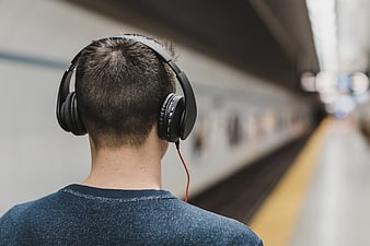 Man with Headphones Waiting at Subway Station