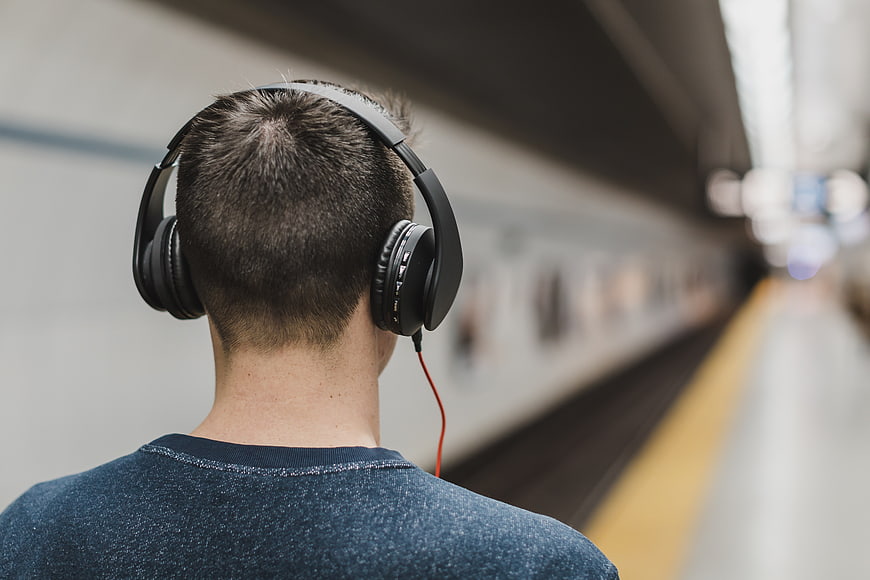 Man with Headphones Waiting at Subway Station