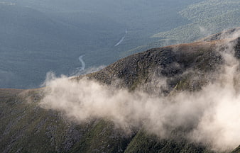 Misty mountain ridge with winding valley road below