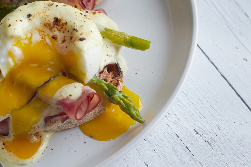 Close-up of Eggs Benedict with Runny Yolk and Asparagus