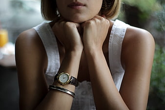 Close-up of woman's wristwatch and bracelet on arms