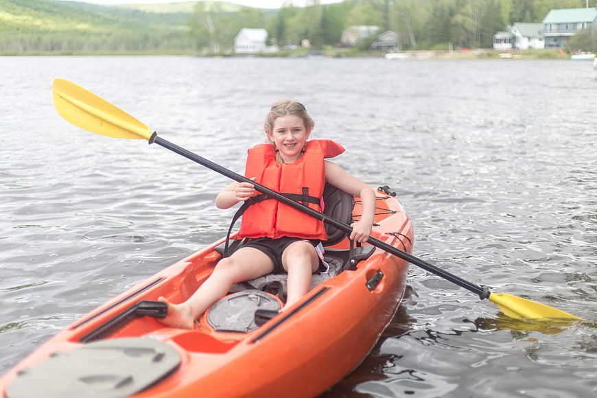 Happy Girl Kayaking on Lake in Summer