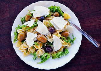 Top view of bowtie pasta salad with olives and cheese