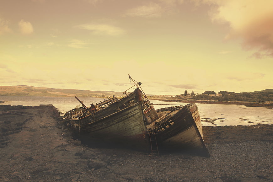 Abandoned wooden fishing boat wreck on rocky shore