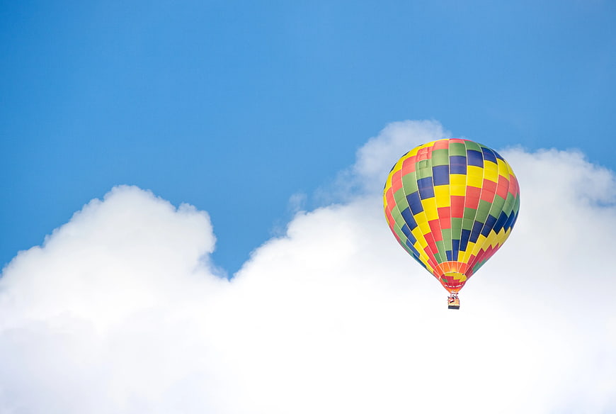 Colorful Hot Air Balloon Flying in Blue Sky with Clouds
