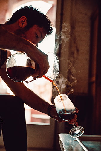 Barista Pouring Hot Coffee into Glass with Steam
