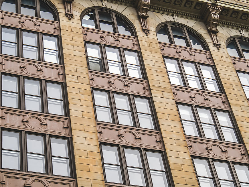 Ornate Beige Stone Building Facade with Arched Windows