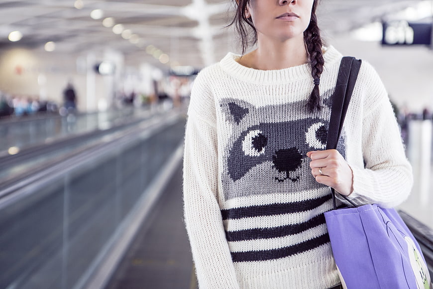 Woman in Raccoon Sweater at Airport
