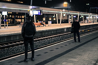 Man waiting for train at night station platform