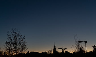 Silhouette of Church Spire and Trees Against Twilight Sky