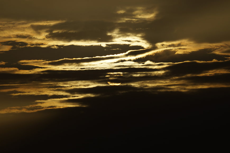 Dramatic Golden Sunlight Breaking Through Dark Storm Clouds