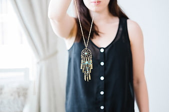 Woman Holding Dreamcatcher Necklace with Turquoise Beads