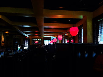 Dimly lit restaurant interior with hanging red pendant lights
