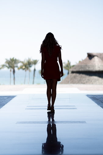 Woman in Red Dress Walking Away by Poolside