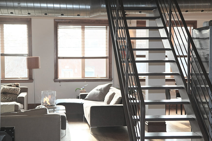 Modern Loft Interior with Metal Staircase and Gray Sofa