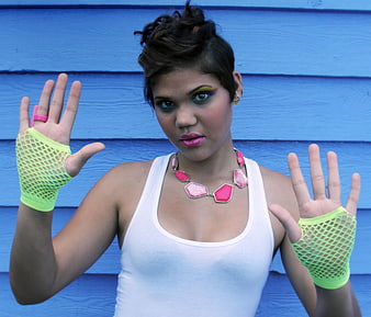 Woman in Neon Fashion Accessories Against Blue Wall
