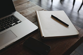 Laptop, Notebook, and Smartphone on Wooden Desk