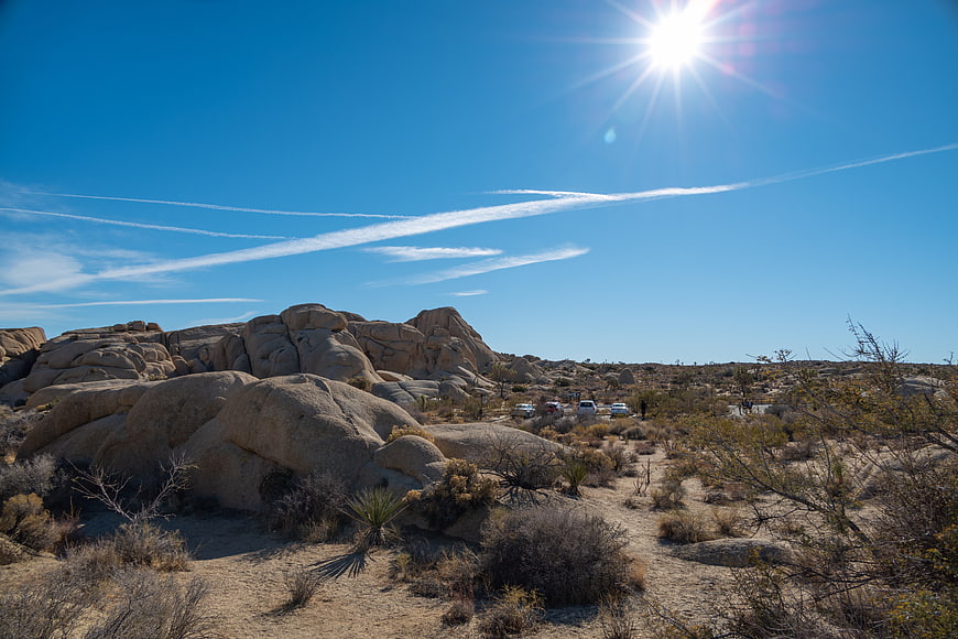 Sunlit desert landscape with rock formations and blue sky