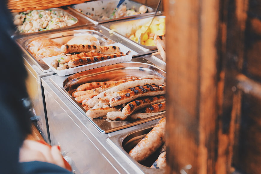 Grilled sausages and buffet food at a catering event
