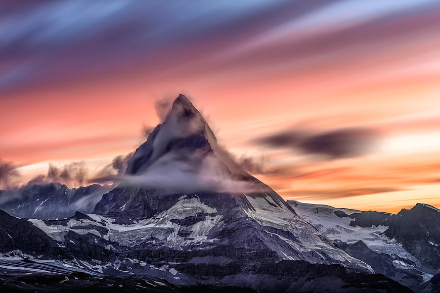 Dramatic Mountain Peak at Sunset with Swirling Clouds