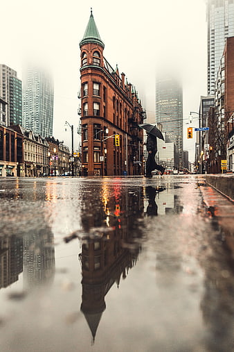 Low angle street photography of rainy city with reflection