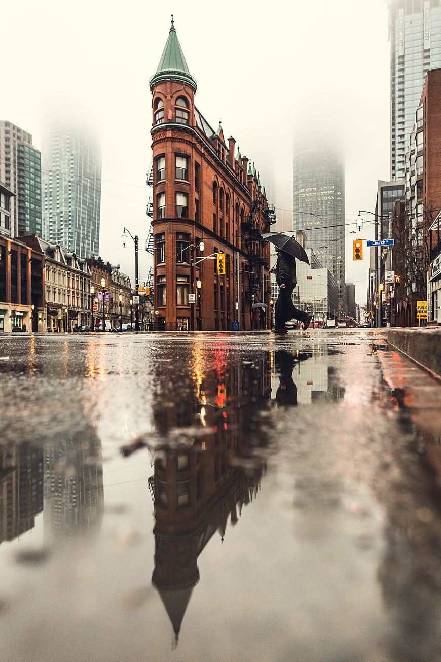 Low angle street photography of rainy city with reflection